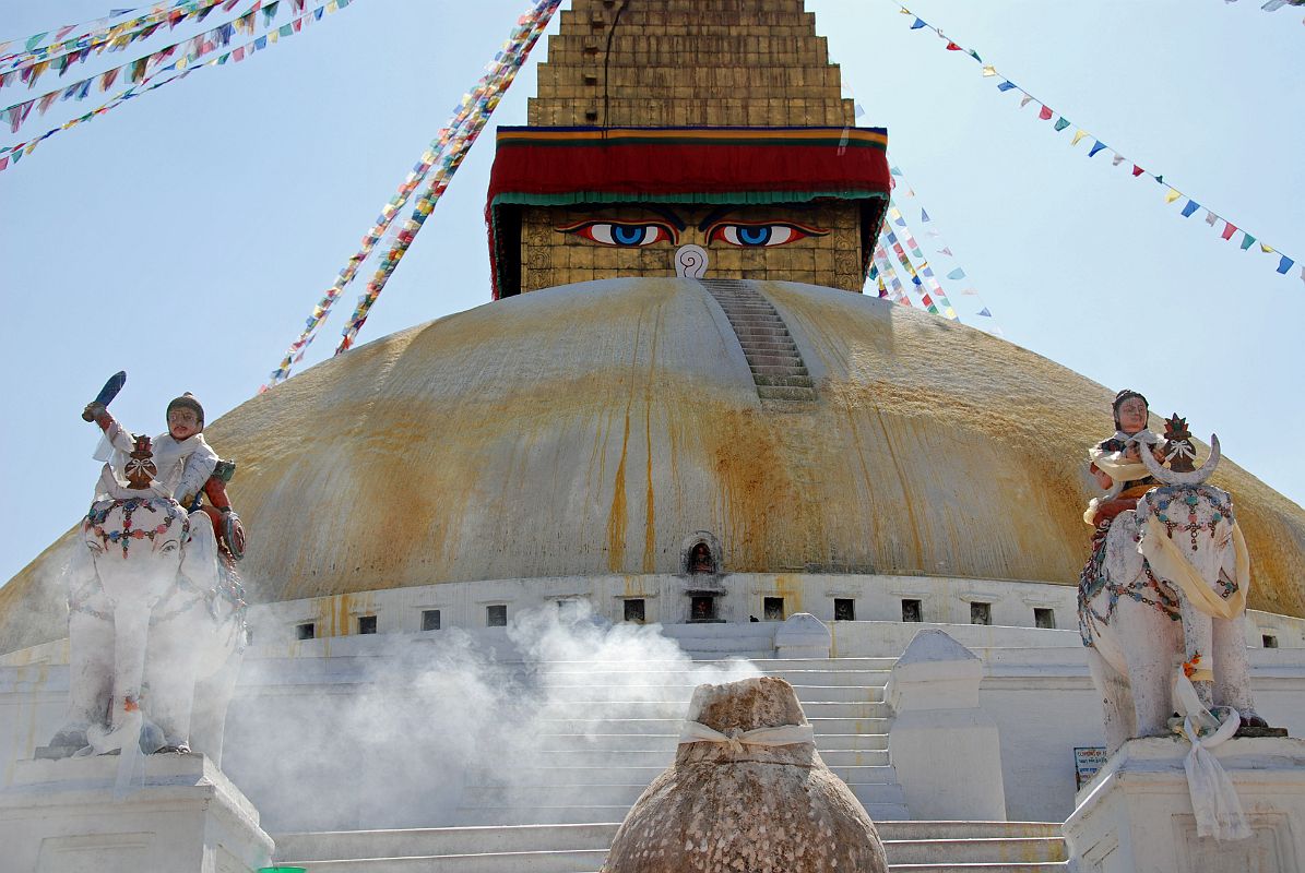 Kathmandu Boudhanath 13 Boudhanath Stupa Entrance Steps, Elephants, Kiln A pair of elephants and a kiln used to burn juniper welcomes you at the entrance to the Boudhanath Stupa itself near Kathmandu. The elephant rider at the left brandishes a sword and shield.